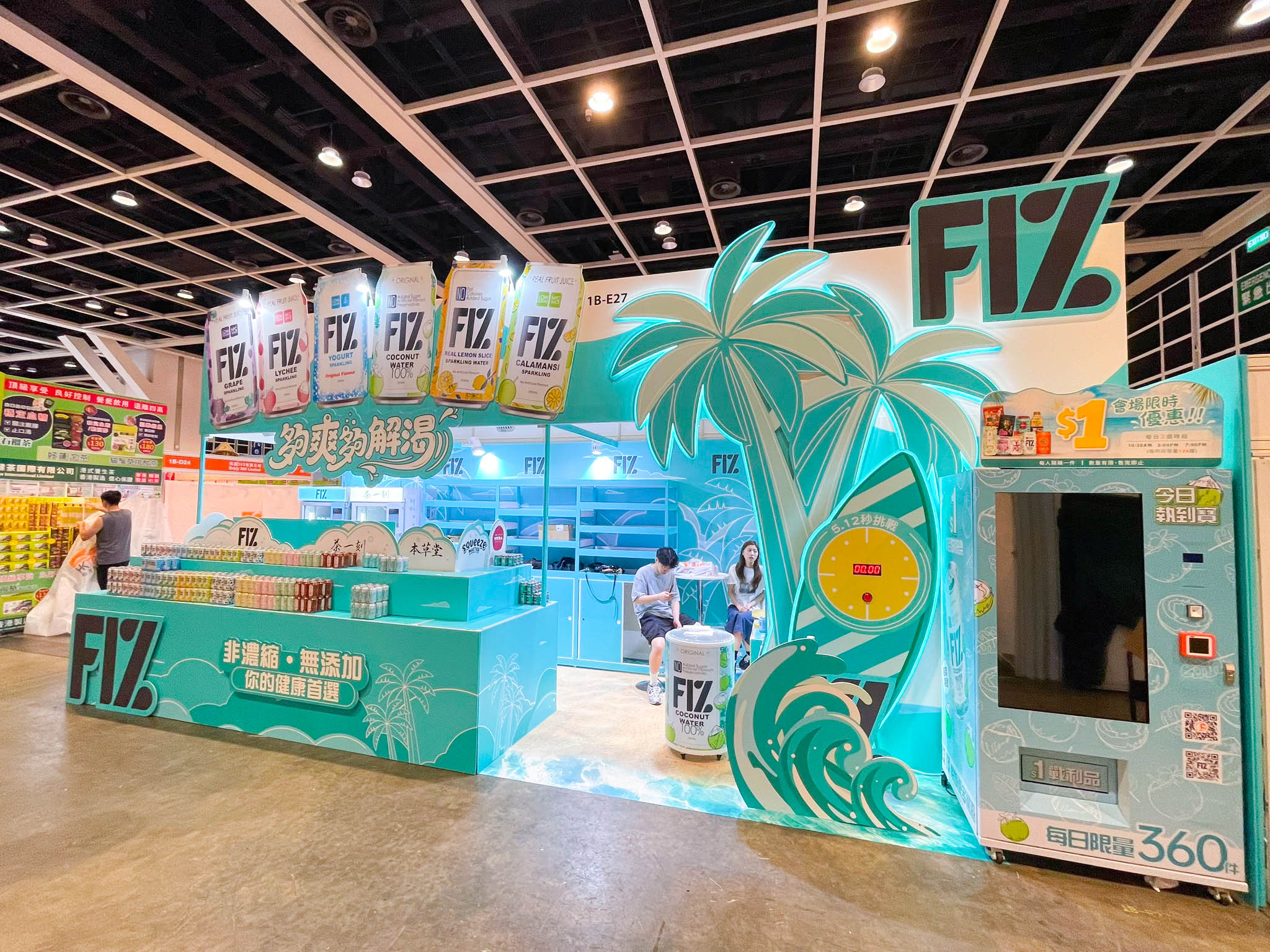 Completed FIZ booth exterior showing product counters, suspended beverage packs, palm tree, 5.12-second challenge, wave decoration and vending machine